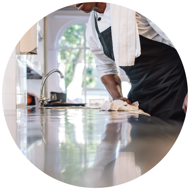 A chef wiping the kitchen countertop