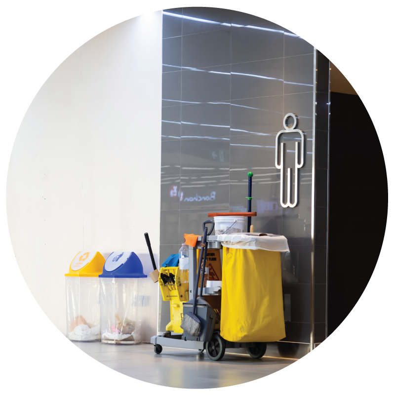 A janitor's cleaning cart outside of men's room in a commercial building