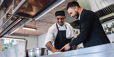 an expert speaking with head chef at the commercial kitchen