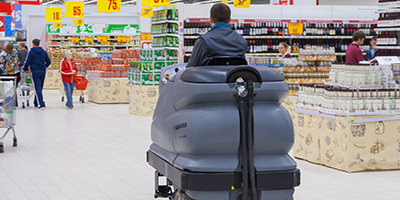 man riding auto scrubber in the supermarket