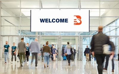 people walking in a convention center lobby with welcome BradyPLUS sign hanging from the ceiling - NorCal Expo