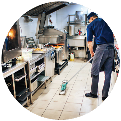 a kitchen staff mopping the kitchen floor at the restaurant