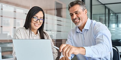 two specialists discussing products looking at a laptop