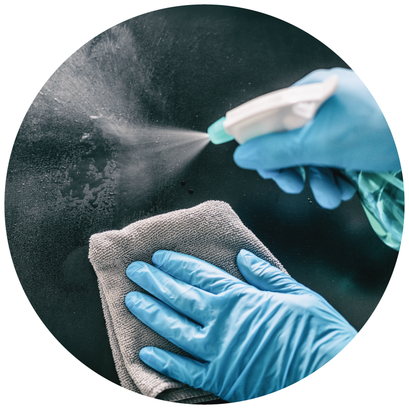 janitor wearing blue gloves cleaning glass with chemical cleaning solution