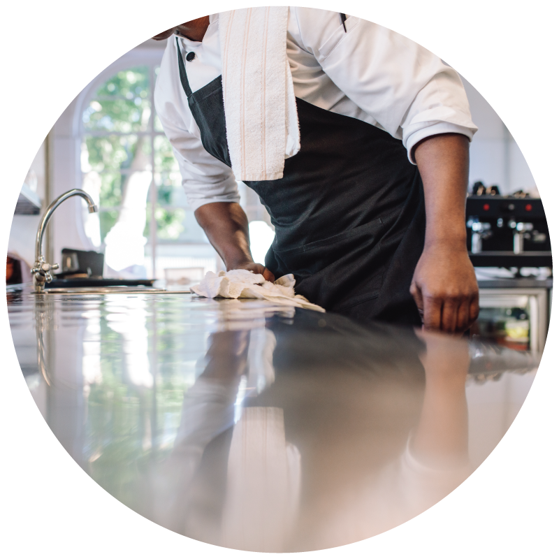 a chef wiping countertop in the commercial kitchen