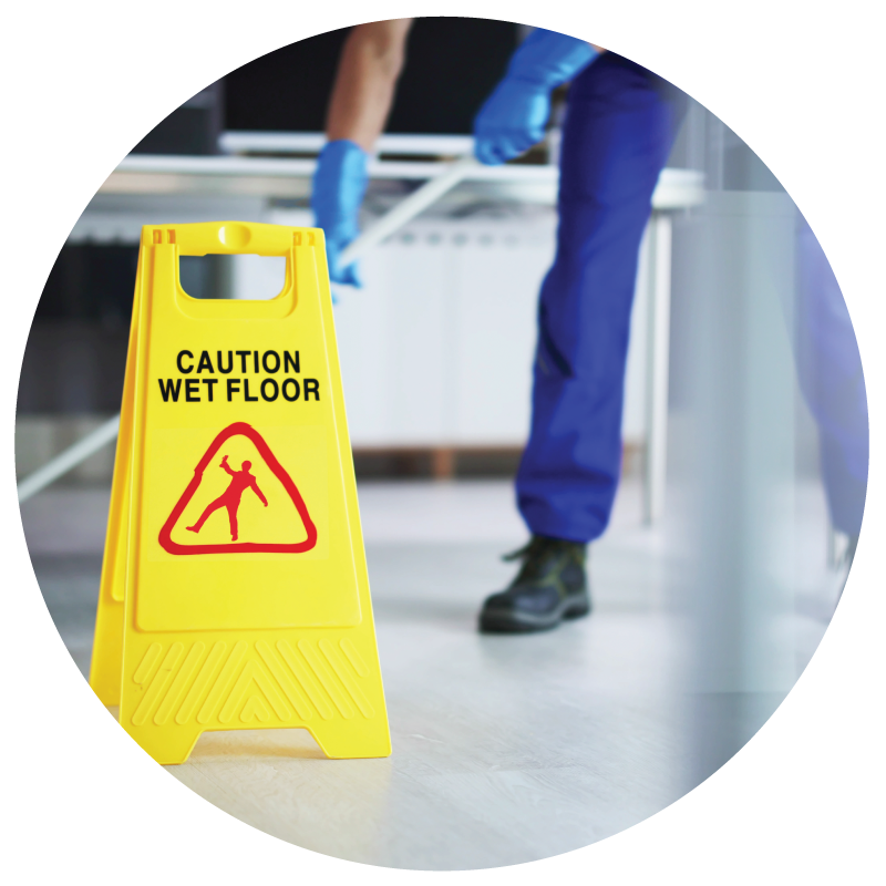 A janitor mopping floor with caution we floor sign on