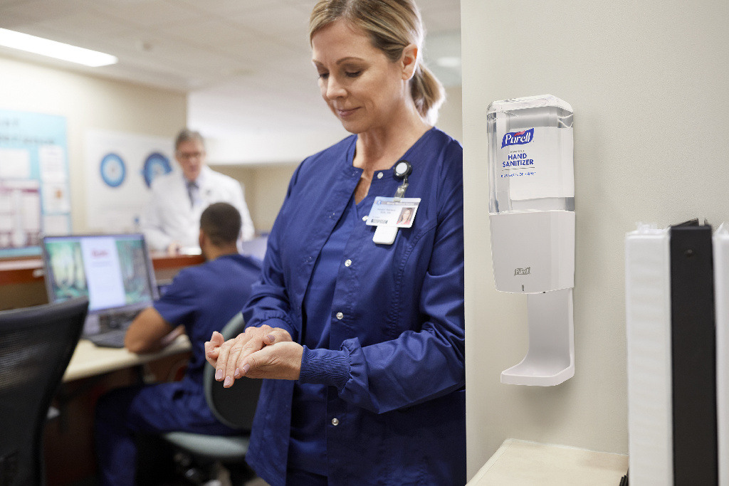 a healthcare professional using PURELL hand sanitizer in the hospital