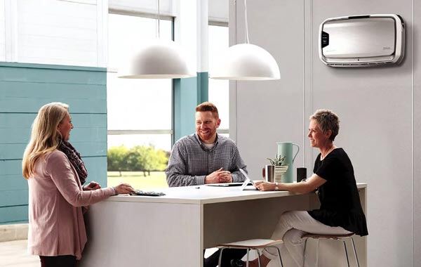 three professionals making conversations with air purifier showing on the office wall