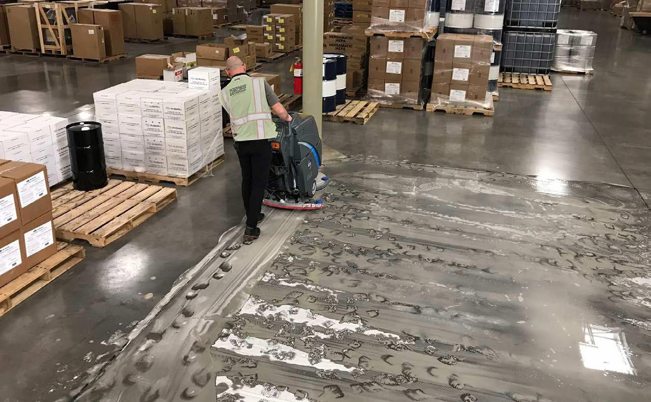 a facility staff scrubbing concrete floor using floor machine